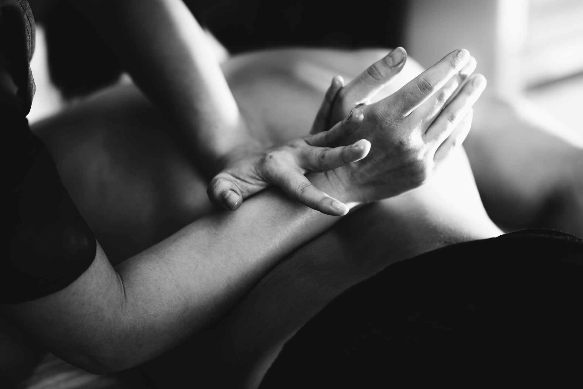 Physiotherapist massaging male patient with injured lower back muscle. Sports injury treatment.
